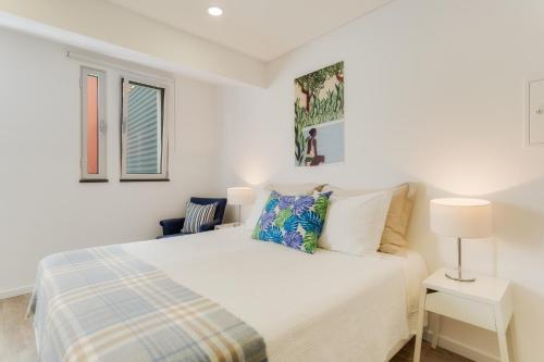 a white bedroom with a bed and two windows at Casa da Praça Double room - by Casas na Ilha in Funchal