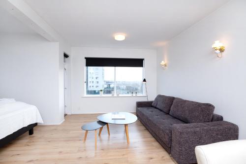 een woonkamer met een bank en een tafel bij City view, bright & cozy - Free parking (A4) in Reykjavík