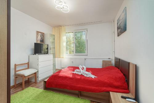 een slaapkamer met een rood bed en een rode deken bij Stone Gate Apartment #2 in Boekarest