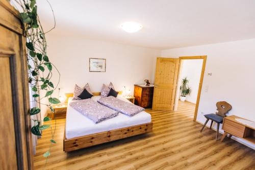 1 dormitorio con 1 cama y suelo de madera en Stimpflhof, en Aldino