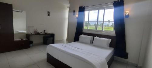 1 dormitorio con 1 cama grande y ventana en VIVIDEARTH Resorts Bandipur en Bandipūr