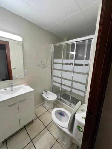 a bathroom with a toilet and a bidet and a sink at Habitación acogedora en BCN in Esplugues de Llobregat