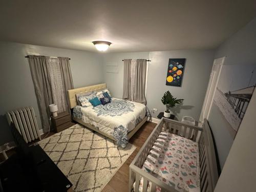 1 dormitorio con 1 cama y 1 cuna en 4 bedrooms & 2 bathrooms “Dhanu’s place”, en Scranton