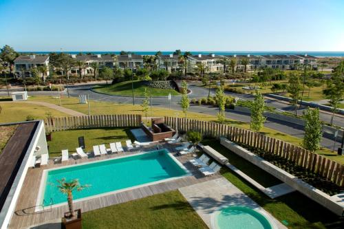 an overhead view of a swimming pool in a resort at The Editory By The Sea Troia Comporta Hotel in Troia