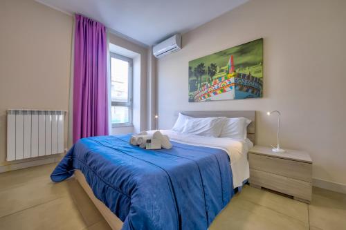 sypialnia z łóżkiem z niebieskim kocem w obiekcie Residence I Dioscuri by RECEPTIO w Katanii
