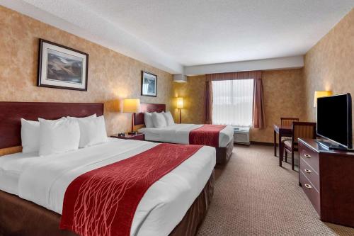 a hotel room with two beds and a flat screen tv at Comfort Inn Sturgeon Falls in Sturgeon Falls