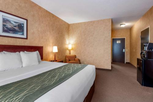Una habitación de hotel con una cama grande y un televisor. en Comfort Inn, en Sturgeon Falls