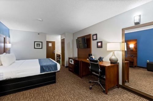 a hotel room with a bed and a desk with a computer at Comfort Inn & Suites St Louis-Hazelwood in Hazelwood