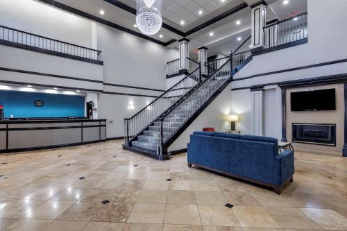 een grote kamer met een trap en een blauwe bank bij Quality Inn & Suites I-35 E-Walnut Hill in Dallas