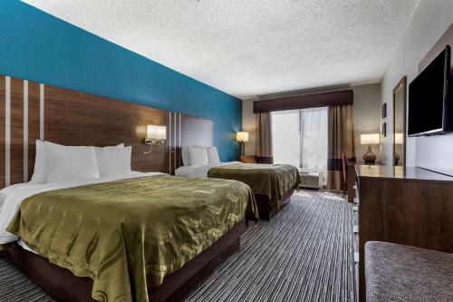 a hotel room with two beds and a flat screen tv at Quality Inn & Suites I-35 E-Walnut Hill in Dallas