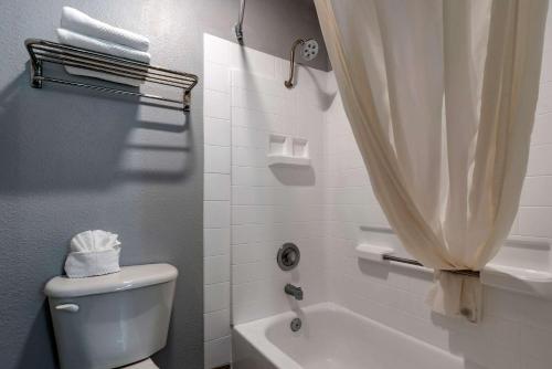 a bathroom with a toilet and a shower curtain at Quality Inn in Madras