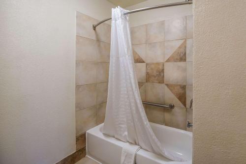 a bathroom with a shower with a shower curtain at Quality Inn & Suites Lufkin in Lufkin