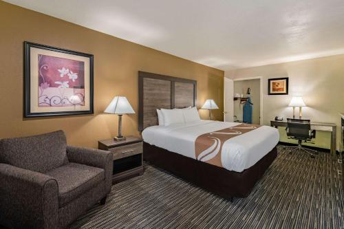 拉夫金的住宿－Quality Inn & Suites Lufkin，配有一张床和一把椅子的酒店客房