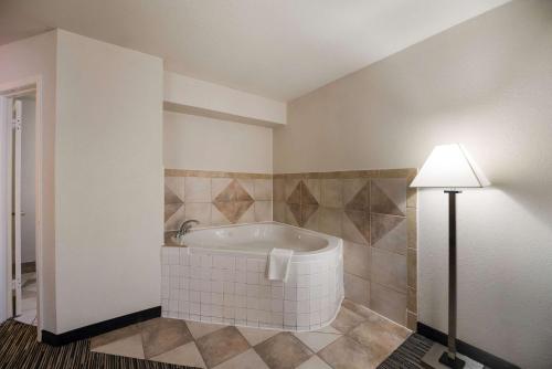 uma casa de banho com uma banheira e um candeeiro em Quality Inn & Suites Lufkin em Lufkin