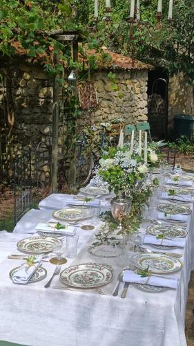 a long white table with plates and flowers on it at 14th Century Priory in Pressigny in Pressigny
