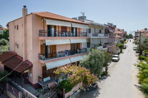 ein Apartmenthaus mit Balkon auf einer Straße in der Unterkunft STUDIOS NIKOS in Limenaria