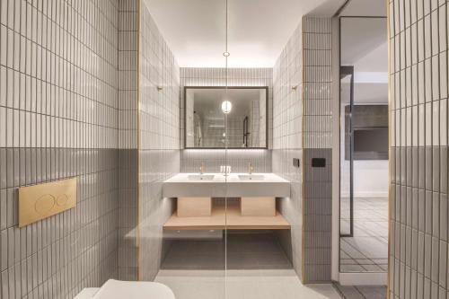 a bathroom with a sink and a mirror at Vibe Hotel Sydney Darling Harbour in Sydney