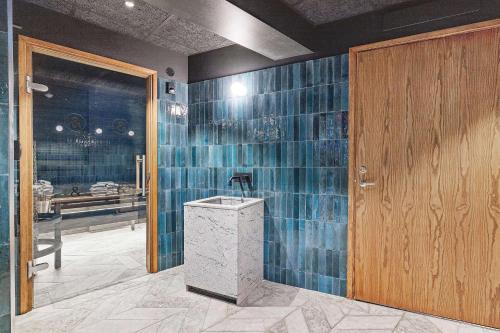 a bathroom with blue tiles on the wall and a wooden door at Best Western and Hotel Linkoping in Linköping