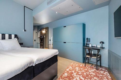 - une chambre avec un grand lit et un mur bleu dans l'établissement Best Western and Hotel Linkoping, à Linköping
