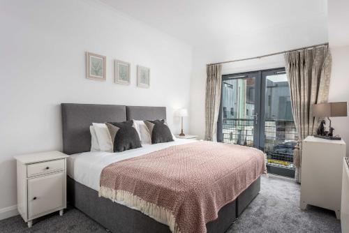 a bedroom with a large bed and a large window at No27 The Barclay - Donnini Apartments in Kilmarnock