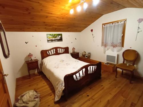 ein Schlafzimmer mit einem großen Bett und einer Holzdecke in der Unterkunft Chambres d'hôtes au pied des Pyrénées 