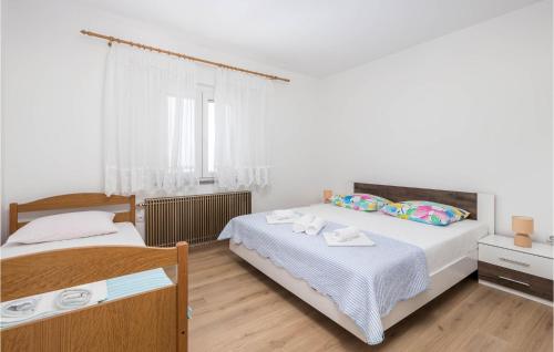 two beds in a bedroom with white walls and wooden floors at Beautiful Home In Sveti Juraj With Wifi in Sveti Juraj