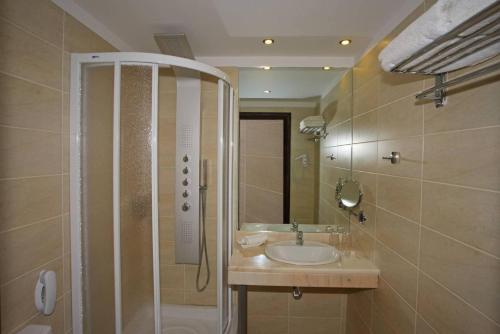 uma casa de banho com um lavatório e um chuveiro em Olympic Palladium em Retimno