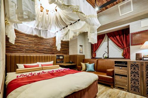 1 dormitorio con 1 cama grande y 1 sofá en Petit Bali Ikebukuro, en Tokio