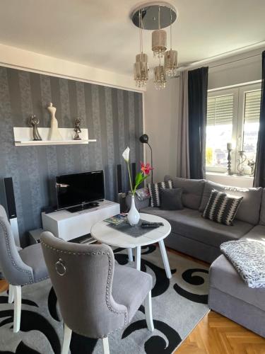 a living room with a couch and a table and chairs at LEA-Lux Apartment in Čačak