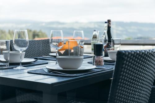 a table with wine glasses and a table set for a meal at HEIMATEL - Suiten, Apartments und Studios in Scheidegg