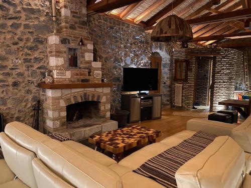 a living room with a couch and a fireplace at Villa Ardamis Karyes in Karyes