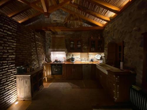 a large kitchen with wooden cabinets and a brick wall at Villa Ardamis Karyes in Karyes