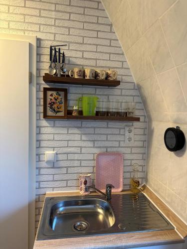 a small kitchen with a sink and a shelf at StarHouse Ferienwohnung Hamburg in Hamburg