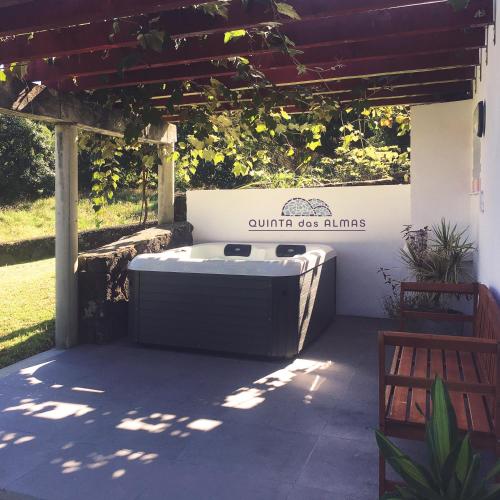 a hot tub on a patio under a pergola at Quinta das Almas in São Roque do Pico