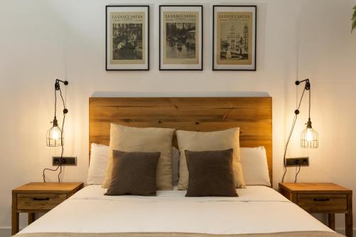 バルセロナにあるKeyFamily Paradiseの白いベッド1台、壁に3枚の絵が飾られたベッドルーム1室