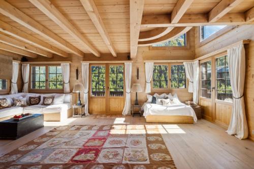 a room with a bed and a couch and windows at Chalet Lo Villâzo by Mrs Miggins in Grimentz