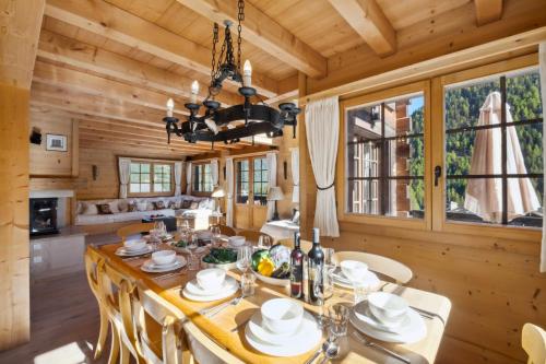 uma sala de jantar com uma grande mesa de madeira e cadeiras em Chalet Lo Villâzo by Mrs Miggins em Grimentz