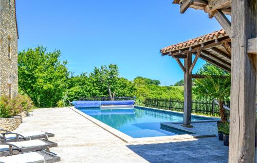 a swimming pool in a backyard with a wooden pergola at Amazing Home In Fleurac in Fleurac