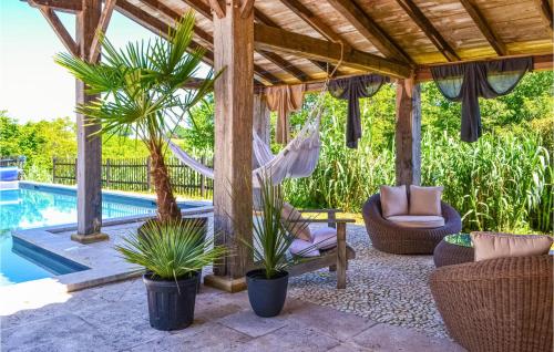 un patio avec un hamac et une piscine dans l'établissement Amazing Home In Fleurac, à Fleurac