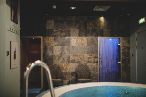 a bathroom with a bath tub with a blue water at Malmaison Birmingham in Birmingham