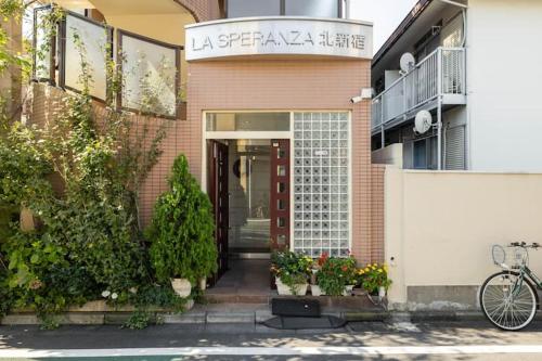 una entrada a un edificio con una puerta roja en 都心の家-ダブルベットと畳み3人部屋 en Tokio