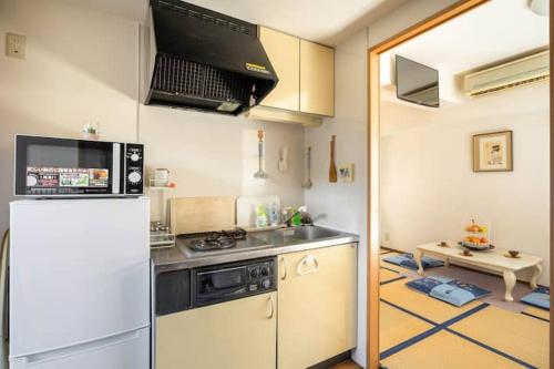 東京的住宿－都心の家-ダブルベットと畳み3人部屋，厨房配有炉灶和冰箱。