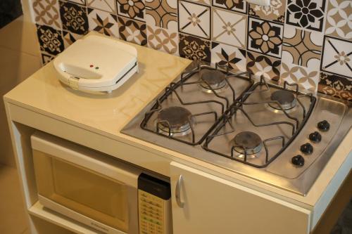 a stove top oven sitting on top of a microwave at Casa Pequena, Completa e Aconchegante - Tiny House in Palmas