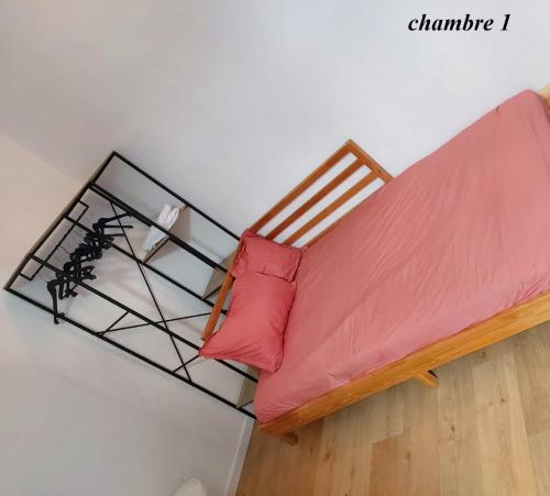 a bed with a red pillow on top of it at Chambres privatives avec espaces partagés dans maison Roubaix centre in Roubaix
