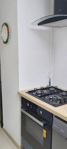 a kitchen with a stove and a clock on the wall at Chambres privatives avec espaces partagés dans maison Roubaix centre in Roubaix
