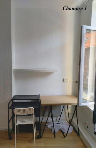a desk and a chair in a room at Chambres privatives avec espaces partagés dans maison Roubaix centre in Roubaix
