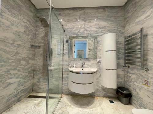 a bathroom with a sink and a shower at Central Park apartment in Baku