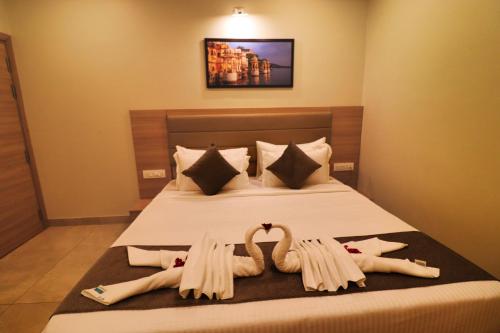 a bedroom with two swans towels on a bed at Clarks Inn Express Udaipur in Udaipur