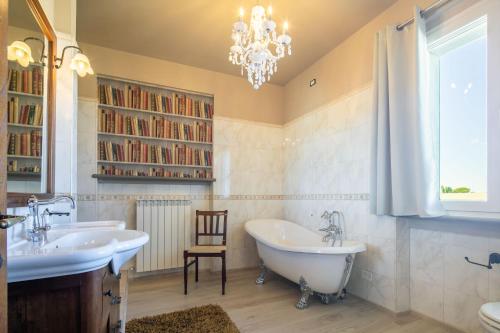 La salle de bains est pourvue de 2 lavabos et d'un lustre. dans l'établissement Casa Romano by VacaVilla, à Cortone