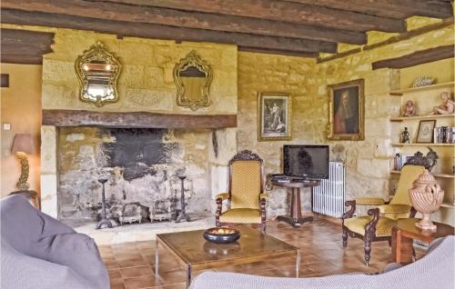 - un salon avec une cheminée en pierre et des chaises dans l'établissement Nice Home In Domme With Wifi, à Domme